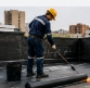 Operario aplicando manto asfáltico en la cubierta de una edificación