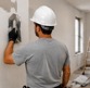 Operario aplicando estuco en la pared de un espacio en remodelación
