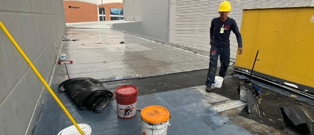 Operario impermeabilizando la cubierta de una edificación